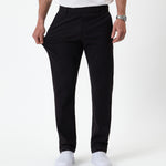 The Proper Pant Regular Fit in black — hand pulling the fabric to show its stretch
