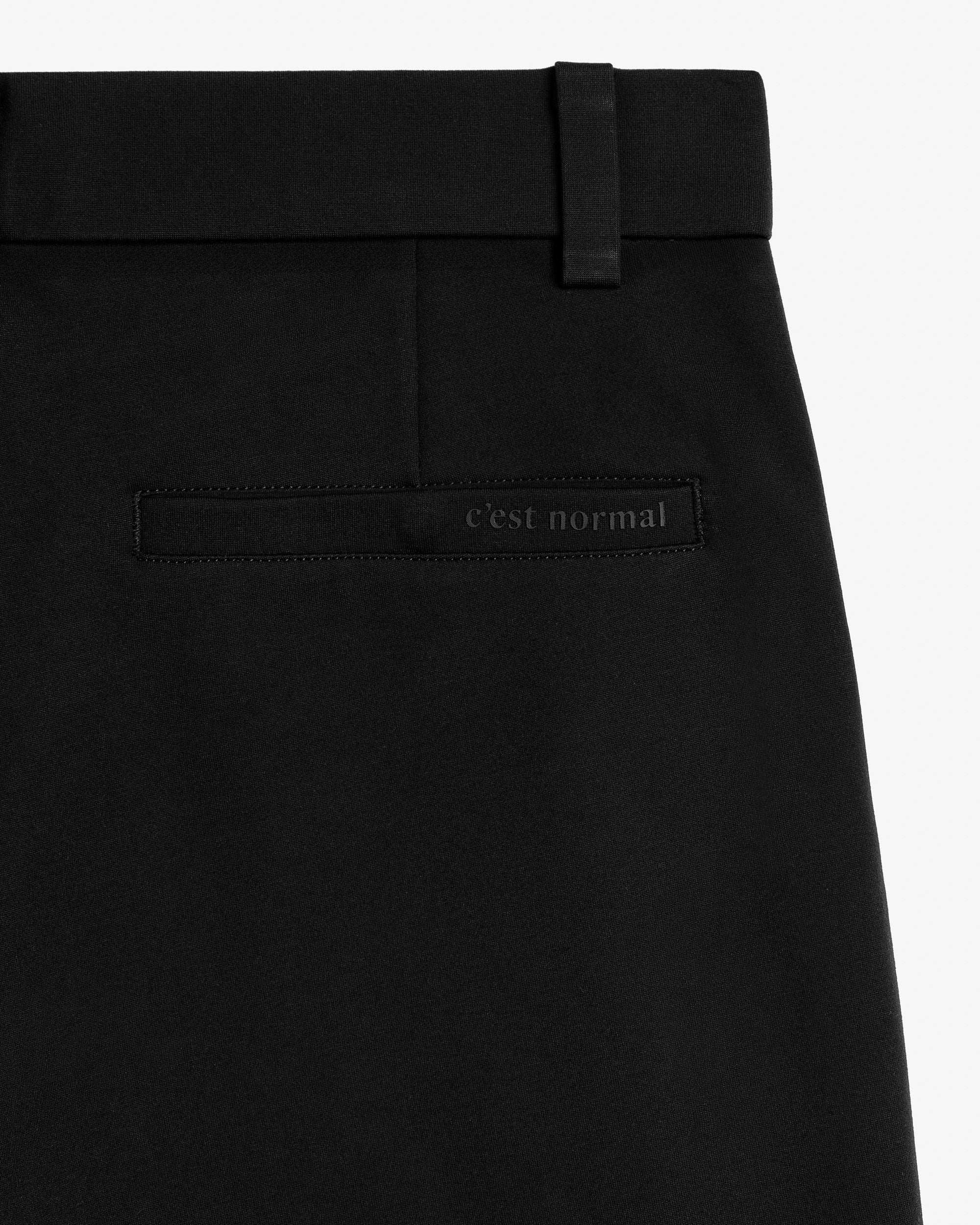 The Proper Pant Relaxed Straight Fit in black — back pocket with C'est normal logo.