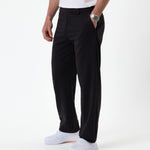 The Proper Pant Relaxed Straight Fit in black — side view styled with white sneakers