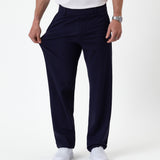 The Proper Pant Relaxed Straight Fit in navy — pulling the fabric to show its stretch