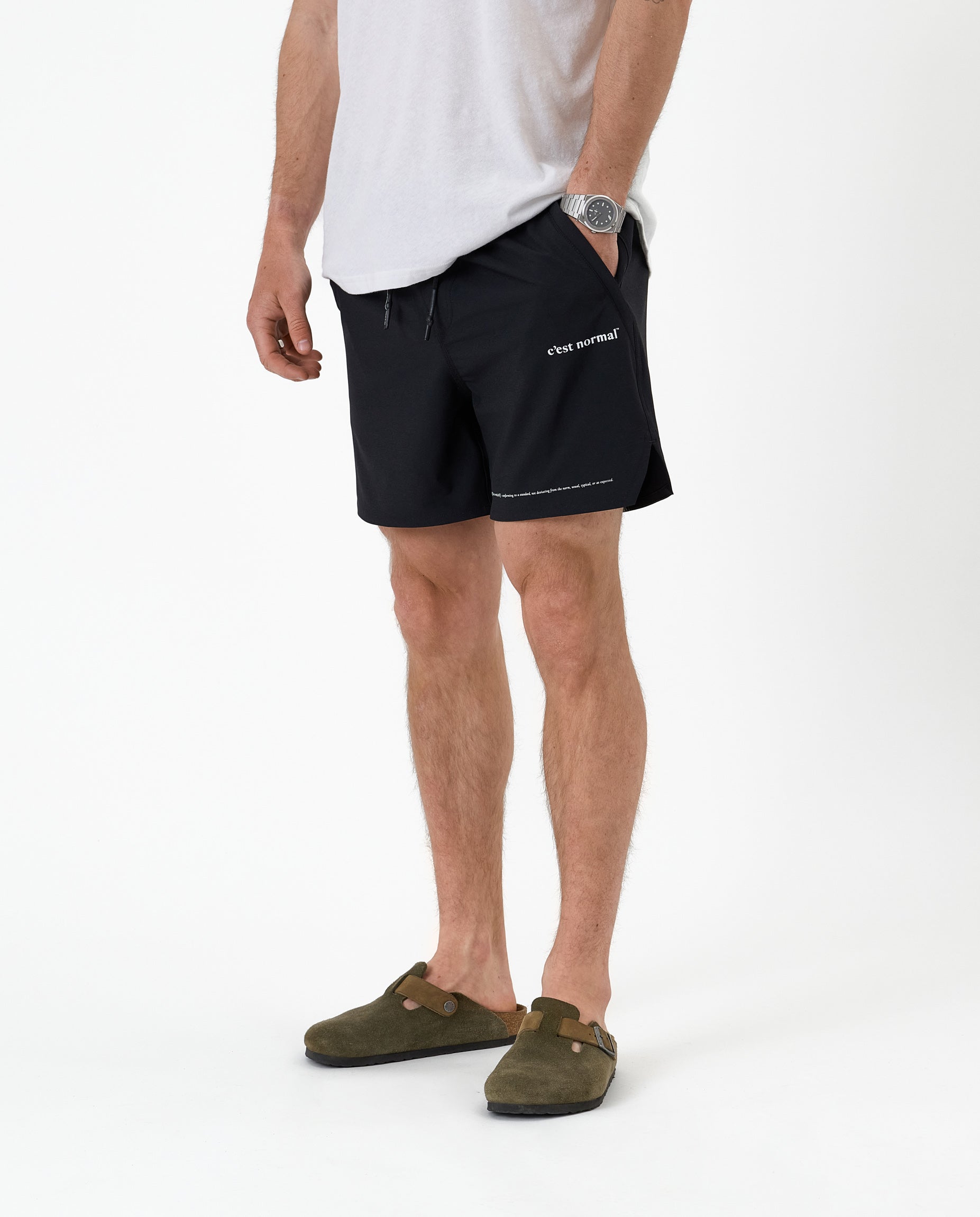 The Shorts in black — worn with olive green clogs and a white t-shirt