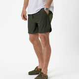 The Shorts in khaki — front view showing the side logo and hand in pocket