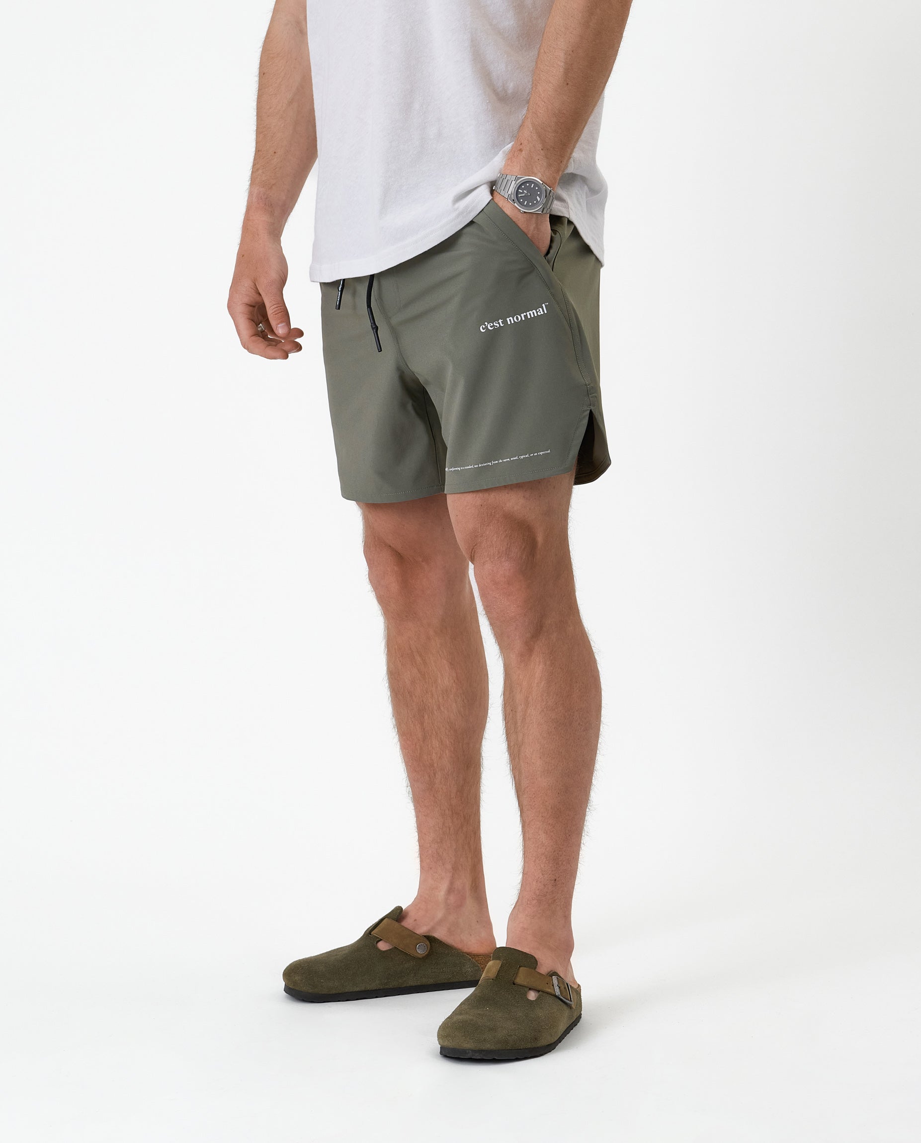 The Shorts in mulled green — side view showing the white logo and notched hem