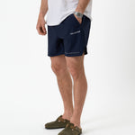 The Shorts in navy — worn with olive clogs and a white t-shirt
