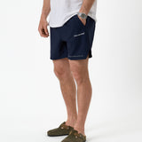 The Shorts in navy — worn with olive clogs and a white t-shirt