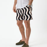 The Shorts in Noir Curl Stripe — worn with a white t-shirt and olive green clogs