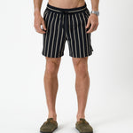 The Shorts in noir stripe — front view worn with olive green clogs