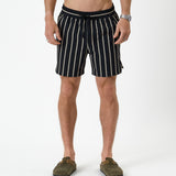 The Shorts in noir stripe — front view worn with olive green clogs