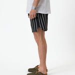 The Shorts in Noir Stripe — side view showing the notched hem and vertical stripes