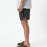 The Shorts in Noir Stripe — side view showing the notched hem and vertical stripes