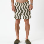 The Shorts in olive curl stripe — featuring a wavy pattern and styled with green clogs