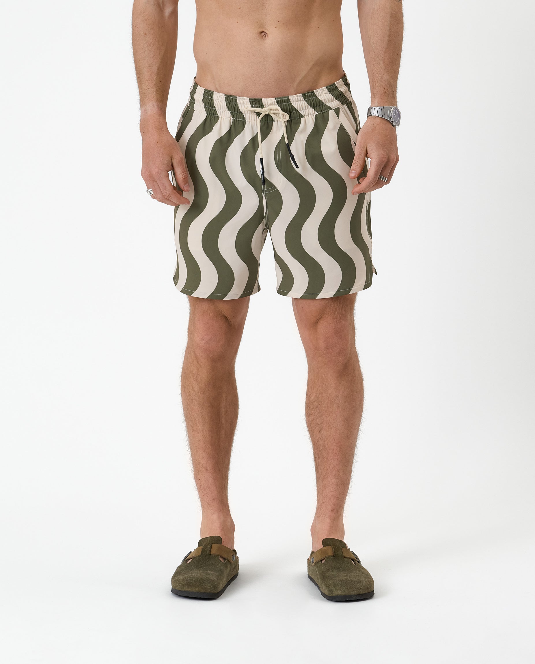 The Shorts in olive curl stripe — featuring a wavy pattern and styled with green clogs