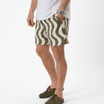 The Shorts in olive curl stripe — worn with olive clogs and a white t-shirt