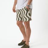 The Shorts in olive curl stripe — worn with olive clogs and a white t-shirt