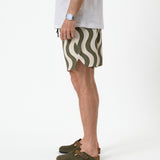 The Shorts in olive curl stripe — side profile showing the notched hem and wavy pattern