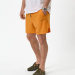 The Shorts in orange peel — worn with olive clogs and a white t-shirt