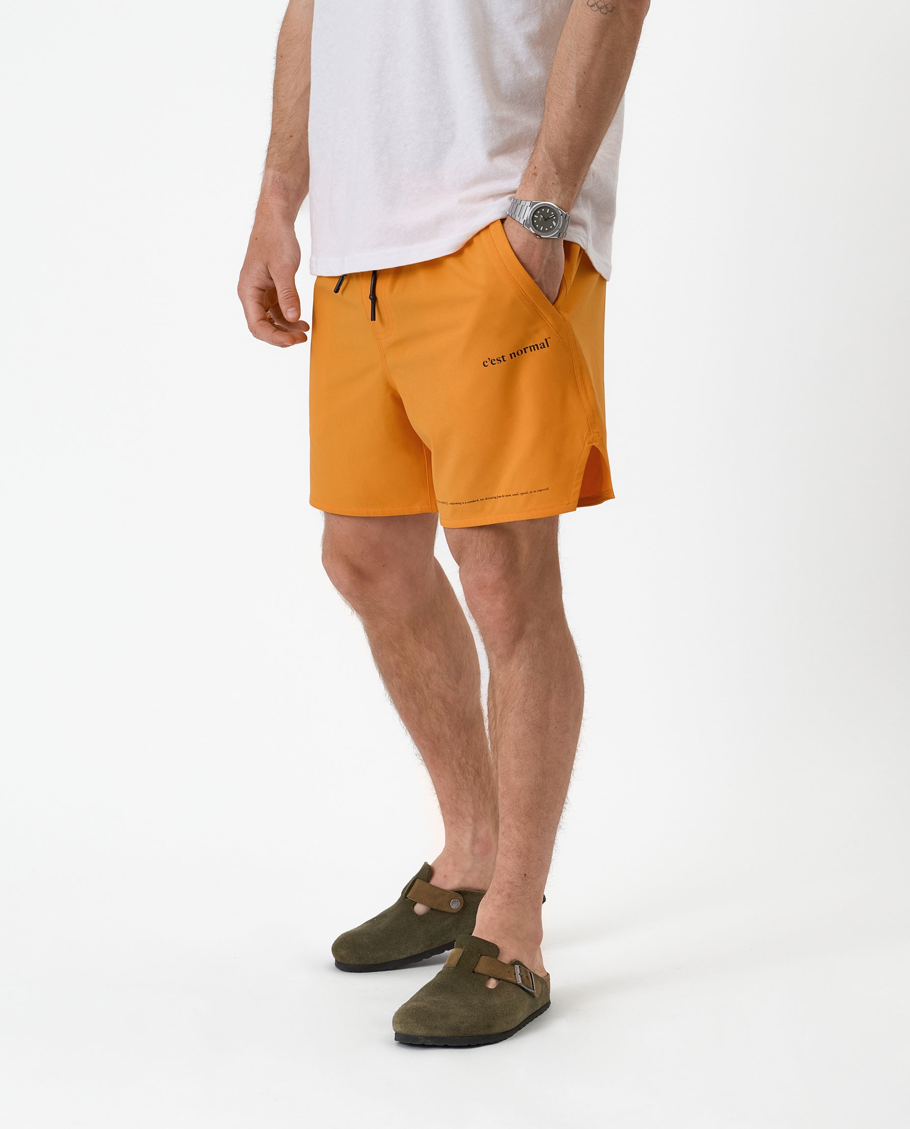 The Shorts in orange peel — worn with olive clogs and a white t-shirt