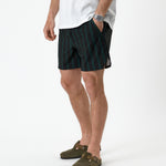 The Shorts in phantom stripe — worn with olive green suede clogs and a white t-shirt