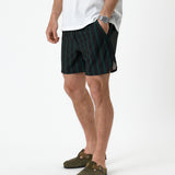 The Shorts in phantom stripe — worn with olive green suede clogs and a white t-shirt