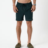 The Shorts in pine — front view worn with olive green clogs