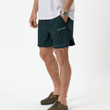 The Shorts in pine — worn with olive green clogs and a white t-shirt