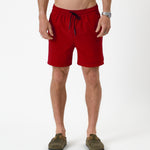 The Shorts in red — front view worn with olive green suede clogs
