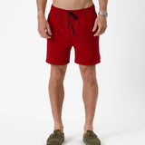 The Shorts in red — front view worn with olive green suede clogs