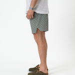 The Shorts in tile — side profile showing the notched hem and green suede clogs
