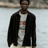 The Workwear Overshirt in black — worn over a C'est normal graphic t-shirt