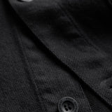 The Workwear Overshirt in black — close-up of the buttons engraved with C'est normal