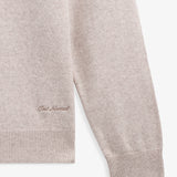 The Toulouse Hoodie in beige — close-up of embroidered C'est normal logo