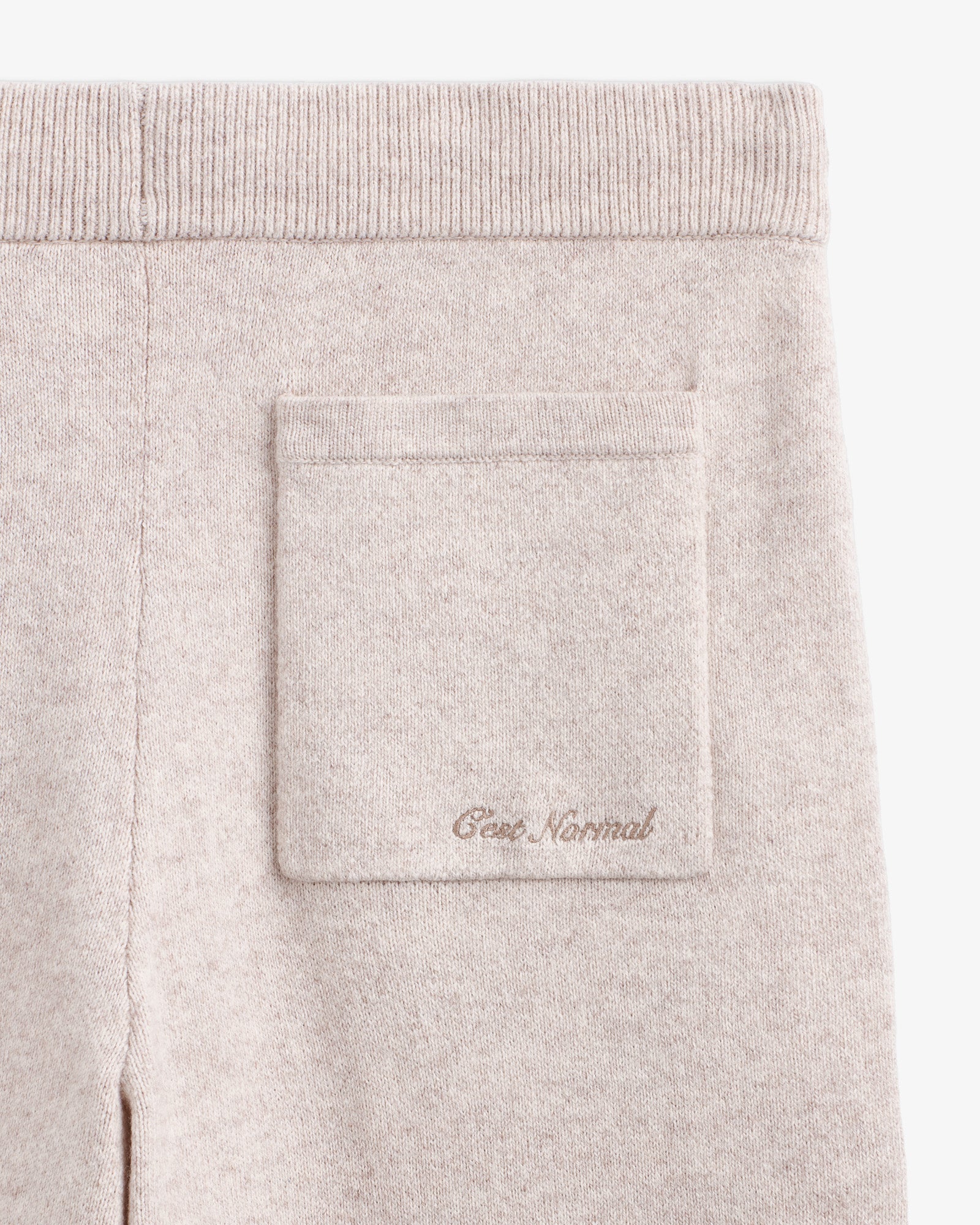 The Toulouse Pant in beige — close-up of the back pocket with C'est normal embroidery