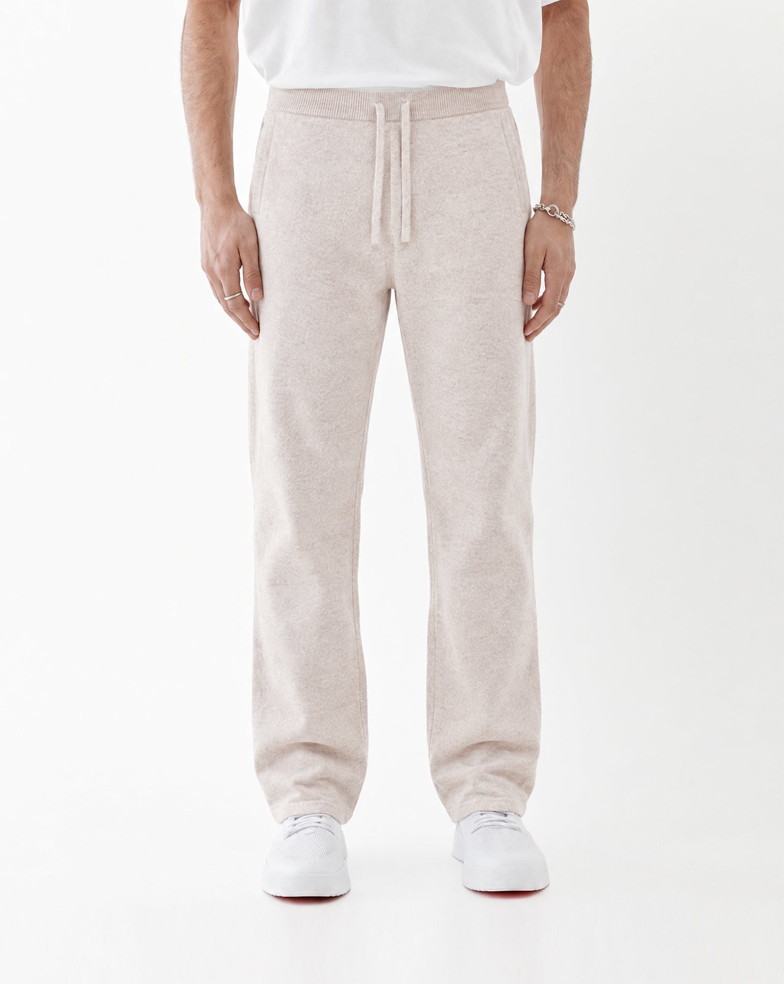 The Toulouse Pant in beige — front view worn with white sneakers