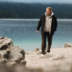 The Carpenter Pants in brown — worn by a man walking by a lake