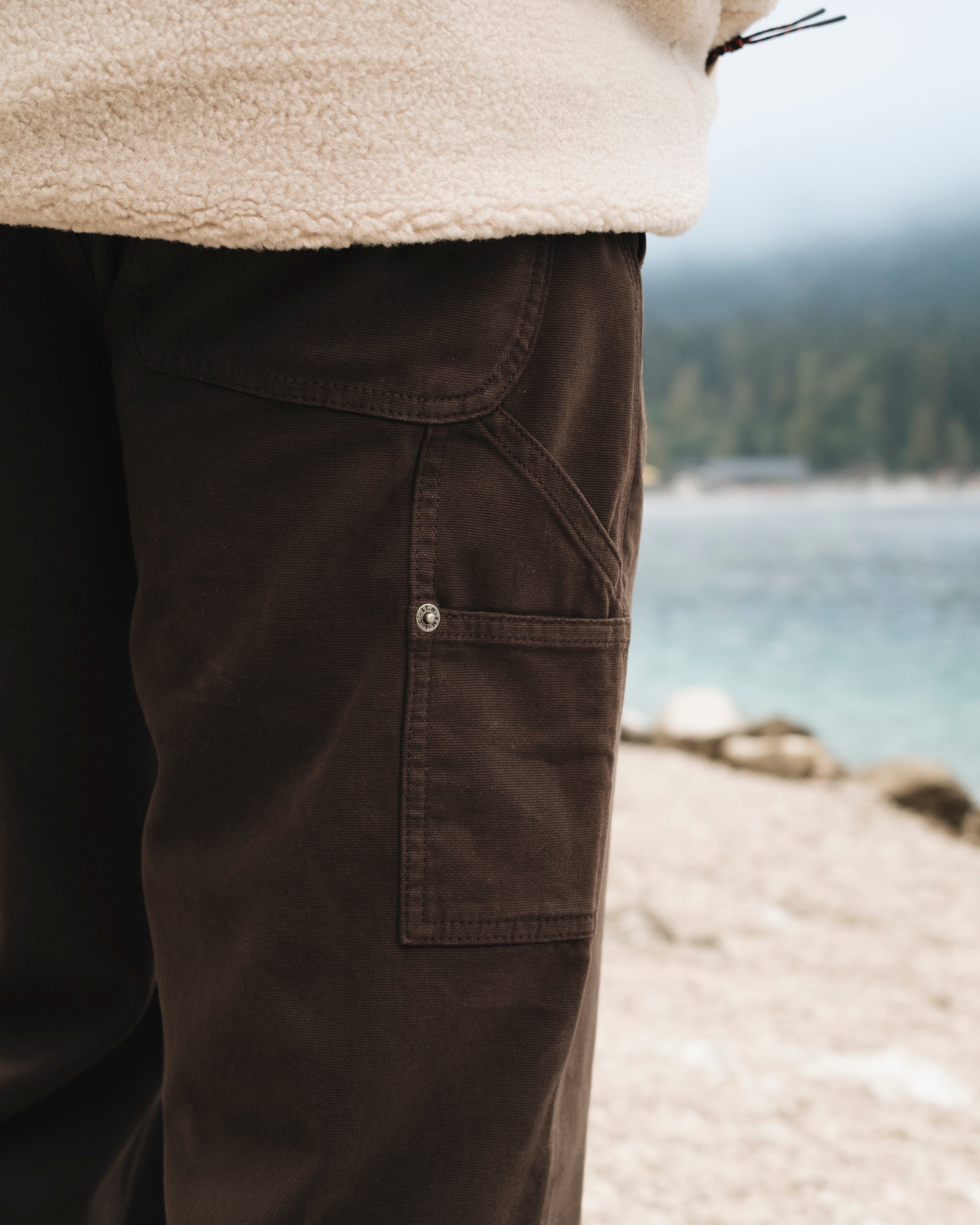 The Carpenter Pants in brown — close-up of side pocket and rivet detail