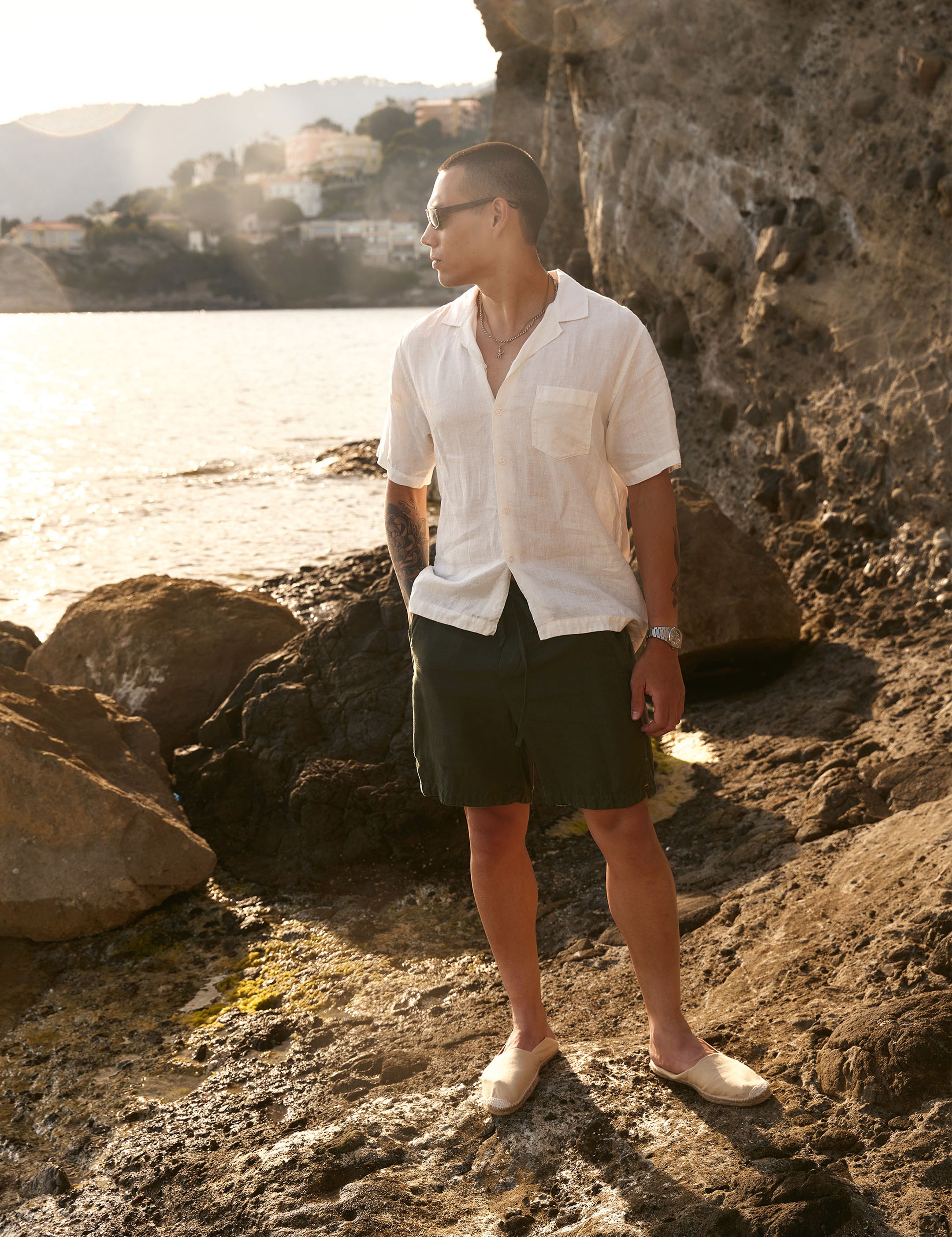 The Holiday Linen SS Shirt in off white — worn on a rocky coast at sunset