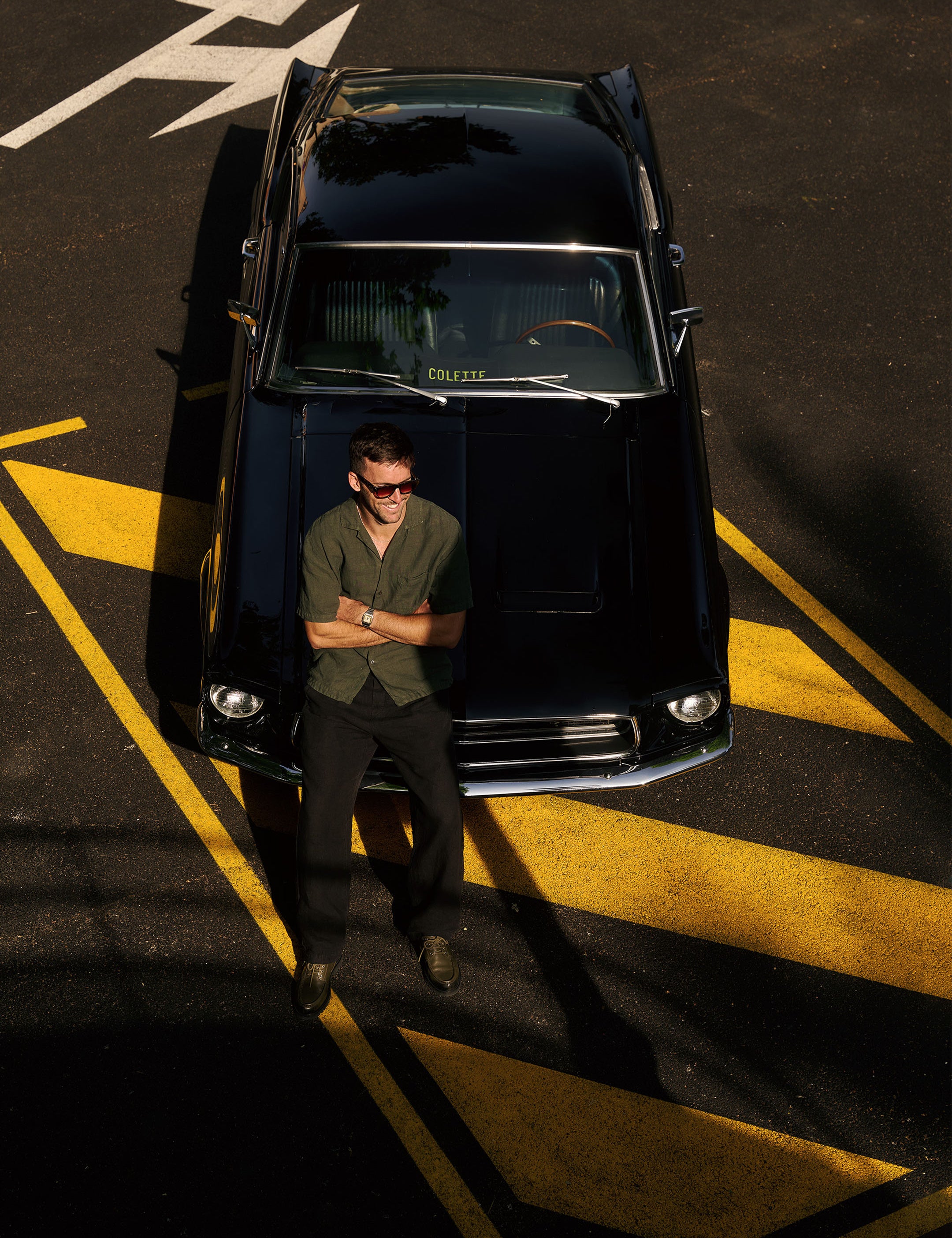 The Holiday Linen SS Shirt in dark khaki — worn while leaning against a vintage black car