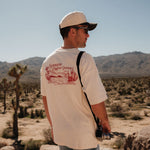 The Oversized Printed T-shirt in cream & red — back view showing the C'est normal desert graphic