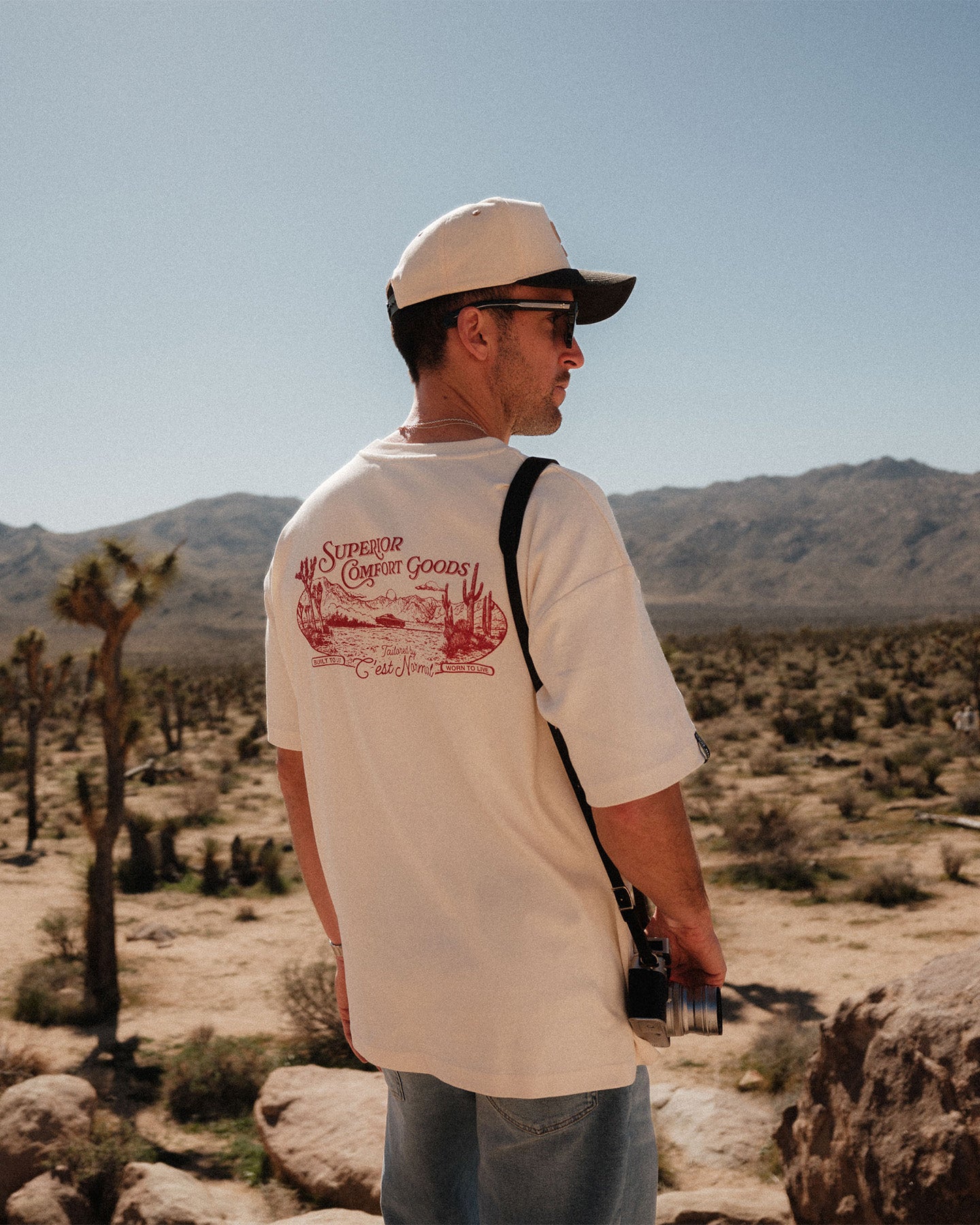 The Oversized Printed T-shirt in cream & red — back view showing the C'est normal desert graphic