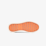 A bottom view of The Sneakers 2.0 in cream, laid flat on a white background. The image highlights the original orange EVA rubber grid sole featuring the c'est normal logo and size detailing in the center.
