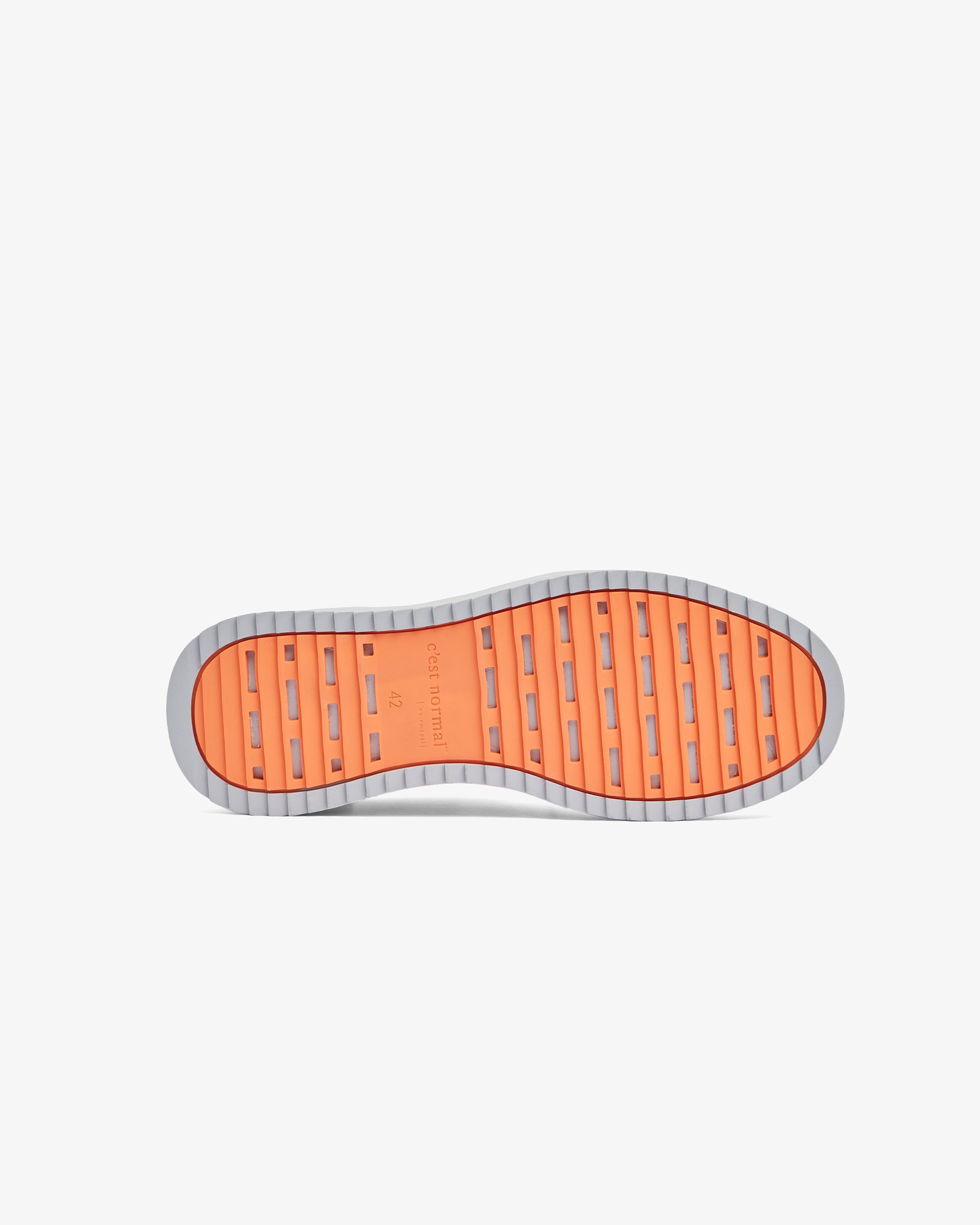 A bottom view of The Sneakers 2.0 in grey, laid flat against a white background. The image shows the EVA rubber grid sole in original orange with the c'est normal logo.
