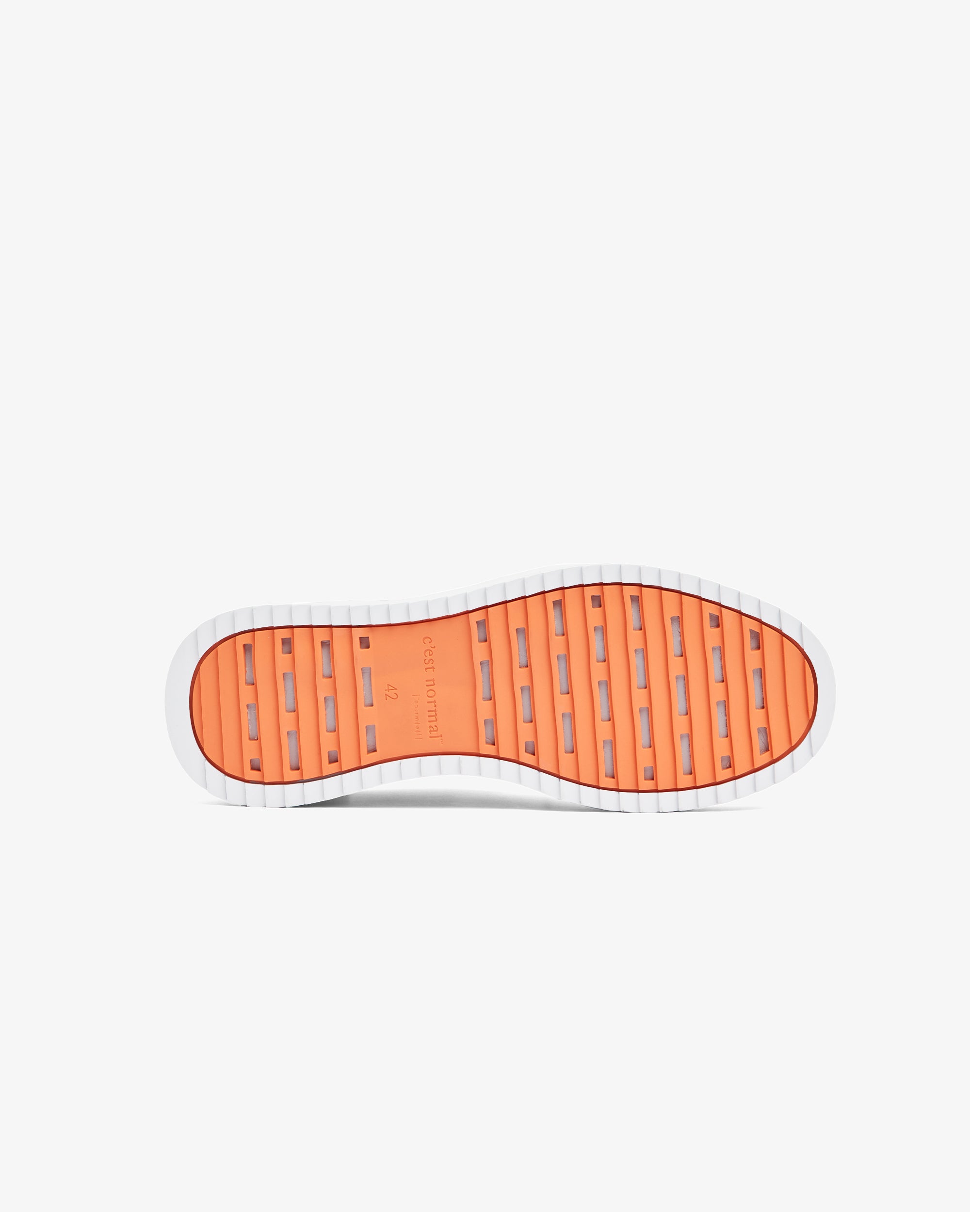 A bottom view of The Sneaker 2.0, showing the EVA rubber grid sole in the original orange color with the c'est normal logo in the center.