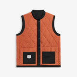 The Utility Vest in rust orange and black — front view showing quilted pattern and front pockets
