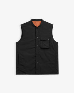 The Utility Vest in black — front view showing the chest pocket and snap button closure