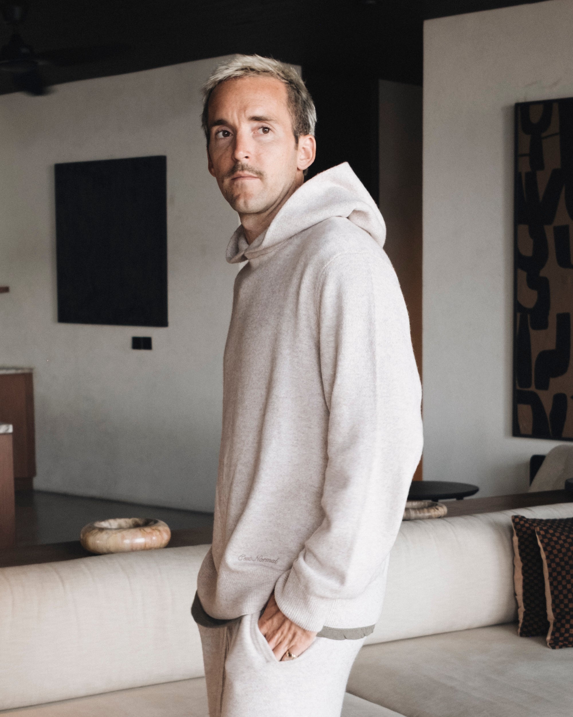 The Toulouse Hoodie in beige melange — worn with the hands in the pocket