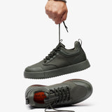 The Dynamic Waterproof Sneaker 2.0 Low in khaki — held up by the laces showing the waterproof upper and orange insole