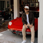 Stockholm Wool Shacket in brown melange — worn while sitting on a red car
