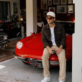 Stockholm Wool Shacket in brown melange — worn while sitting on a red car